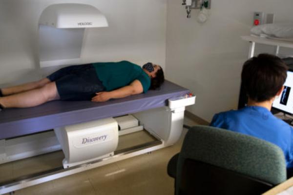 一名参与临床试验的妇女躺在检查室的桌子上，医护人员正在进行测试