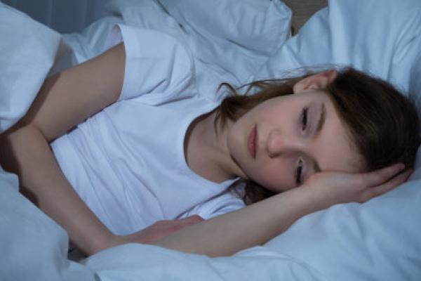 一个患有失眠症的女孩试图在她的床上睡觉。