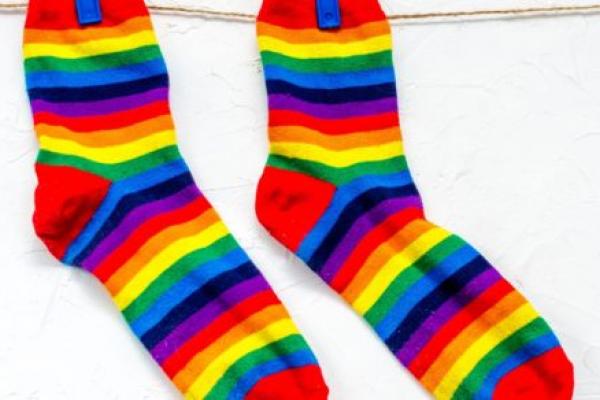 特写一对彩虹色的袜子挂在晾衣绳上。