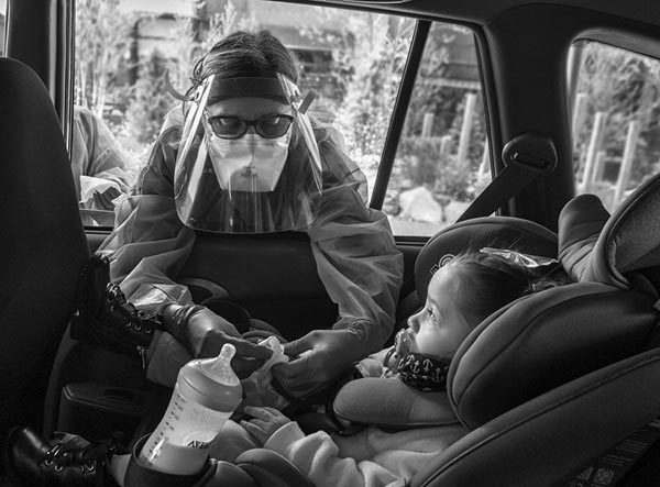 彭妮·波特是宾夕法尼亚州立健康医疗集团的一名护士，她倾身进一辆车，抚摸着两岁的118金宝搏抽水泽恩·佩雷斯-克鲁兹的手指。波特穿着长袍，戴着面罩。孩子坐在汽车安全座椅上，旁边的杯架上有一个瓶子。