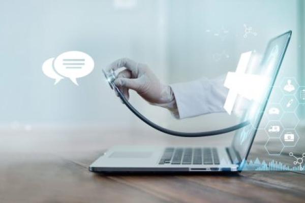 A doctor's hand with stethoscope protrudes from a laptop screen.